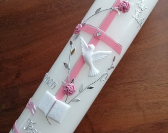 May include: White baptism candle with pink cross, roses, and a dove. Silver accents include leaves and the text "Zur Taufe". The candle also features the name "Tessa" and the year "2020".