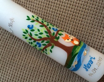 May include: White candle decorated with a tree, blue birds, and a fox. The candle has a blue river with fish and the name "Henri" and the date "14.01.2012" in blue and silver lettering.