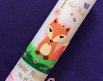 May include: White baptism candle with a pink ribbon and a fox figurine. The candle is decorated with butterflies and the text "Zur Taufe" in gold lettering. The candle also has the name "Sophie Marlene" and the date "04.11.2016" written in gold lettering.
