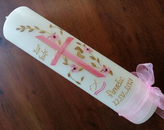 May include: White baptism candle with a pink cross, gold trim, and floral designs. The candle is decorated with a pink ribbon and the text "Liebe Taufe" and "Amelie 22.02.2021".