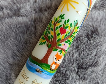 May include: A white baptism candle with a colorful design. The candle features a tree with a red heart, a fox, a bird, a rainbow, and a sun. The text "Elise Antonia 24.02.2024" is written in gold on the candle.