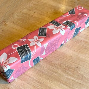 May include: A pink and white gift box with a floral pattern and the text "The Church of Jesus Christ of Latter-day Saints Elder Gonzalez" printed on the front.