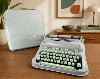 Máquina de escribir Hermes 3000 vintage, color verde menta, estilo curvo, mediados de siglo.