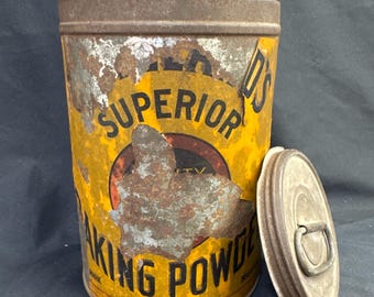 May include: Vintage metal baking powder tin with a yellow and red label. The label reads "SUPERIOR BAKING POWDER" with visible rust and wear. The lid is off to the side.
