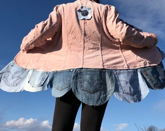 Puede incluir: Una chaqueta de pana rosa con un parche de flor en la espalda. La parte inferior de la chaqueta está hecha de mezclilla con bordes festoneados.