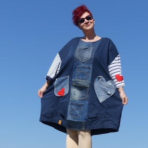 May include: A blue denim dress with red heart patches and a white and blue striped sleeve. The dress has multiple pockets and is made from recycled denim.