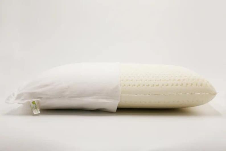 May include: A white pillow with a removable cover. The pillow is made of a breathable, open-cell foam with a textured surface. The cover is made of a soft, white fabric.