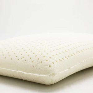 May include: A white latex pillow with a breathable, perforated surface. The pillow is designed for comfort and support.