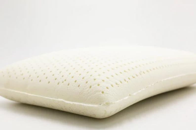 May include: A white latex pillow with a breathable, perforated surface. The pillow is designed for comfort and support.