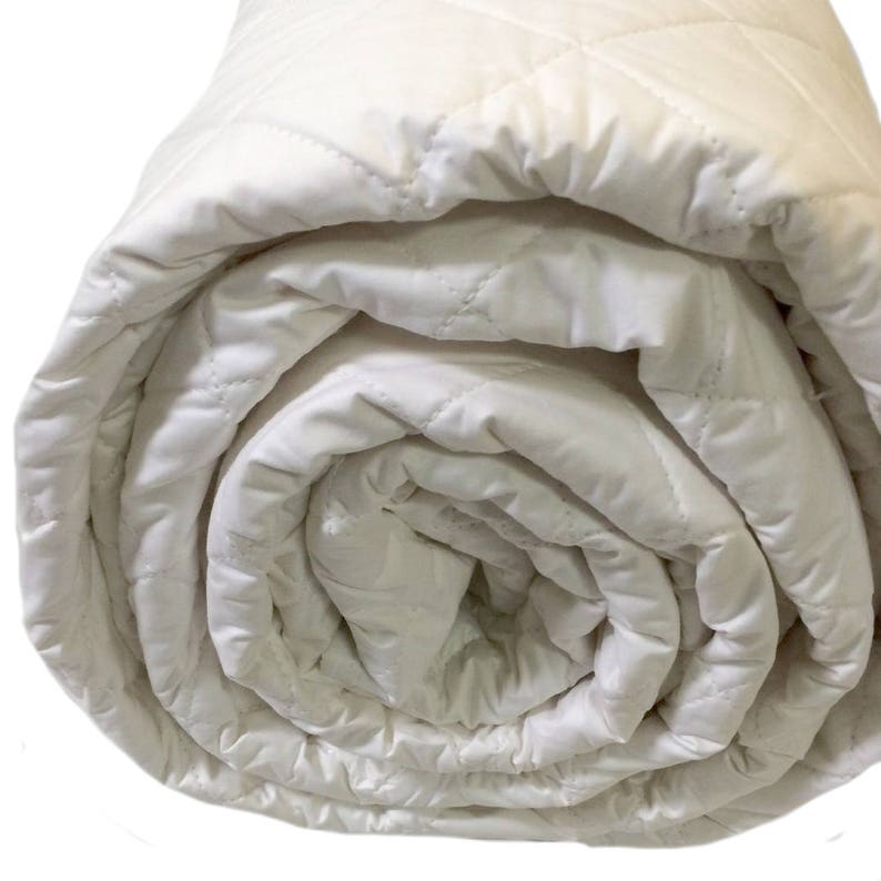 May include: A white quilted mattress topper rolled up tightly. The topper is made of a soft, breathable material and is designed to provide extra comfort and support.