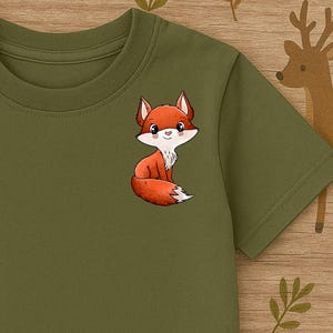 Könnte beinhalten: Olivgrünes T-Shirt mit einem Cartoon-Fuchs-Design. Der Fuchs ist orange, weiß und schwarz. Das Shirt hat einen Rundhalsausschnitt und kurze Ärmel. Der Hintergrund zeigt Illustrationen zum Thema Wald.