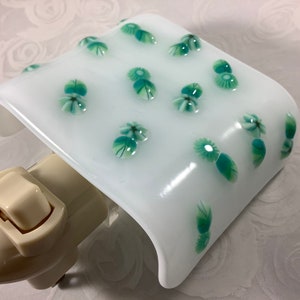 May include: White night light with a green floral design. The night light has a switch on the side.