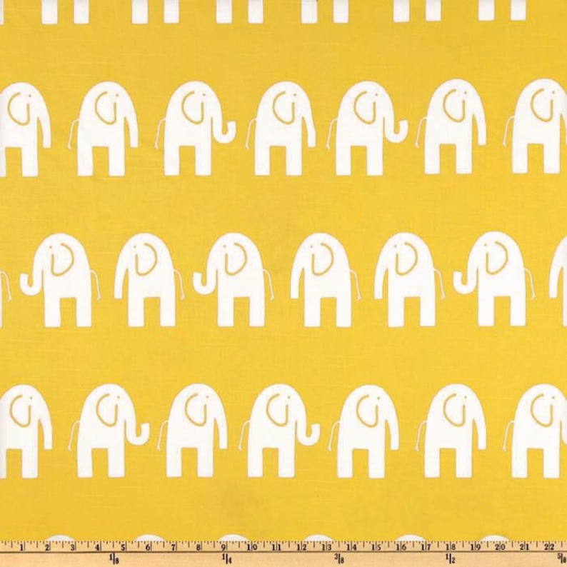 Pu&ograve; includere: Un tessuto giallo con un motivo ripetuto di elefanti bianchi. Gli elefanti sono stilizzati e hanno un design semplice.