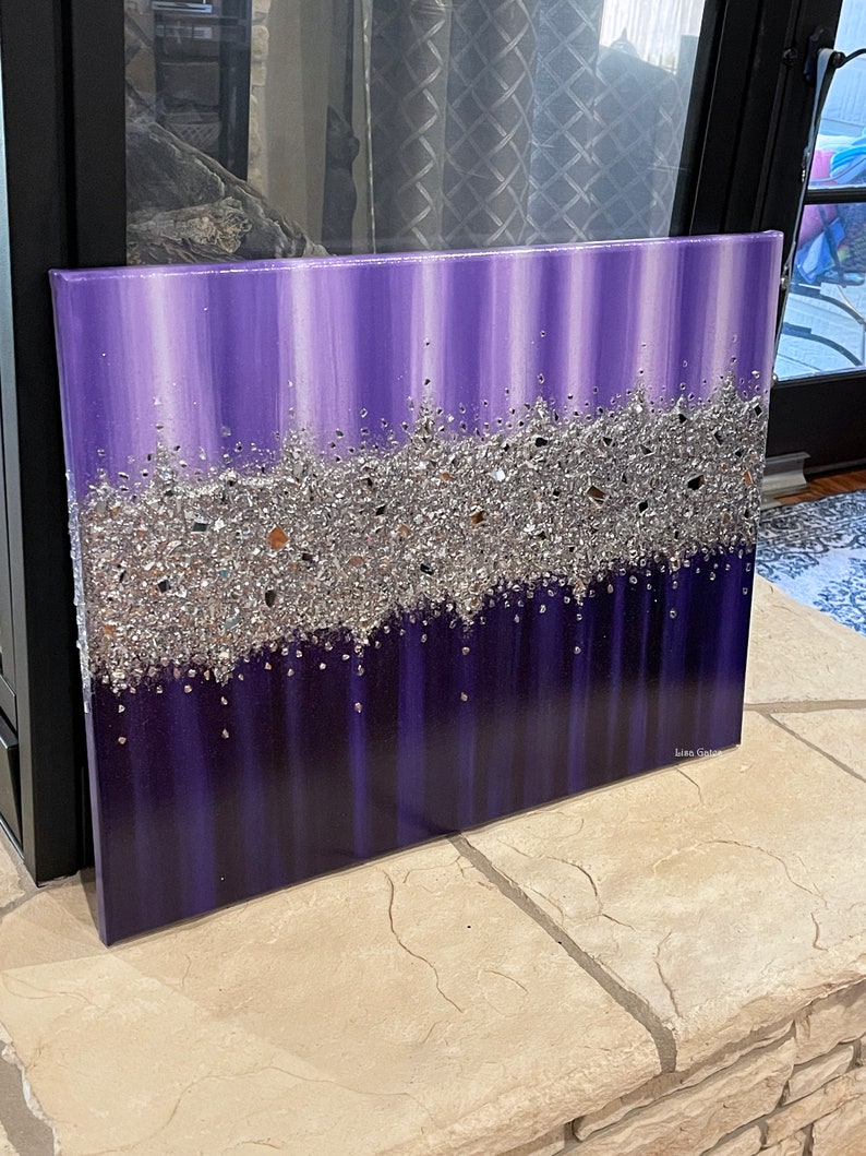 May include: Purple and silver abstract painting with a textured silver glitter layer. The painting is on a canvas and has a white border.