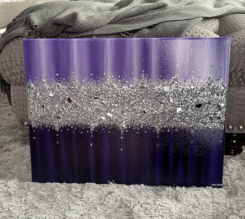 May include: Purple and silver abstract painting with a textured silver glitter layer. The painting is on a canvas and has a white border.