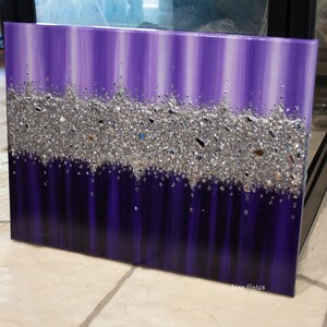 May include: Purple and silver abstract painting with a textured glitter finish. The painting has a vertical stripe pattern and the glitter is concentrated in a horizontal band across the middle of the painting.