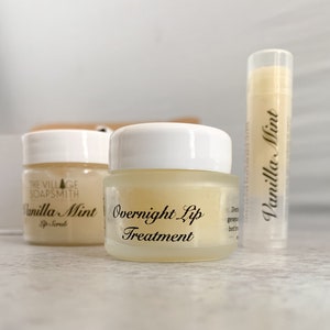 May include: Three lip care products: a lip scrub, overnight lip treatment, and lip balm. The products are in small glass jars and a tube, all labeled "Vanilla Mint." The lip scrub jar is labeled "Lip Scrub" and the overnight treatment jar is labeled "Overnight Lip Treatment."