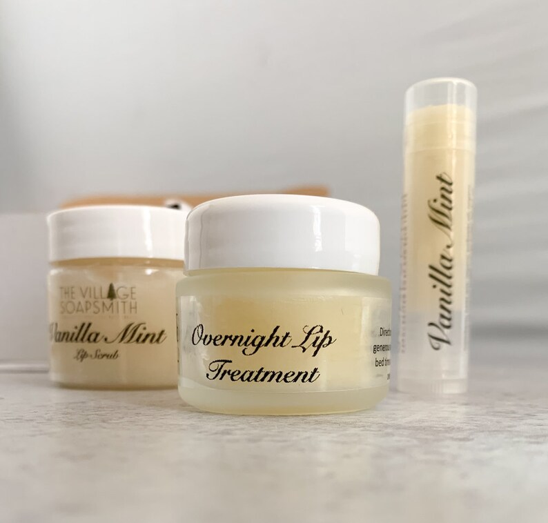 May include: Three lip care products: a lip scrub, overnight lip treatment, and lip balm. The products are in small glass jars and a tube, all labeled "Vanilla Mint." The lip scrub jar is labeled "Lip Scrub" and the overnight treatment jar is labeled "Overnight Lip Treatment."