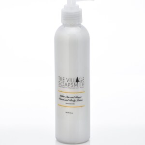 K&ouml;nnte beinhalten: Wei&szlig;e Flasche mit Pumpspender, gef&uuml;llt mit Hand- und K&ouml;rperlotion mit wei&szlig;em Tee und Ingwer mit Ziegenmilch. Die Flasche ist mit "The Village Soapsmith" beschriftet und hat ein Nettogewicht von 8 oz.