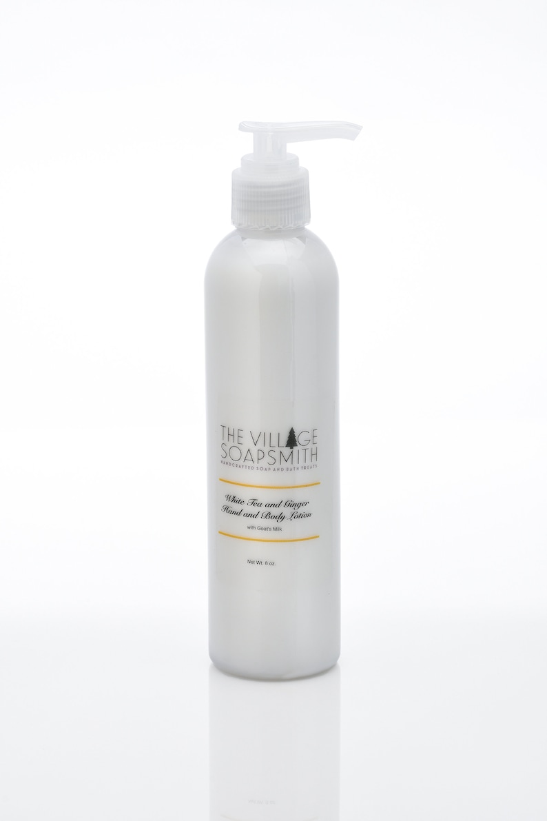 K&ouml;nnte beinhalten: Wei&szlig;e Flasche mit Pumpspender, gef&uuml;llt mit Hand- und K&ouml;rperlotion mit wei&szlig;em Tee und Ingwer mit Ziegenmilch. Die Flasche ist mit "The Village Soapsmith" beschriftet und hat ein Nettogewicht von 8 oz.
