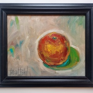 May include: A framed oil painting of a red apple on a green plate. The background is a light beige with blue and green brushstrokes. The painting is signed "Beat Bchl" in the bottom left corner.