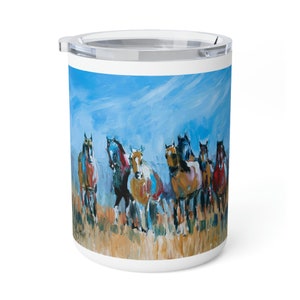 May include: A white ceramic travel mug with a colorful painting of a group of horses running through a field. The horses are various shades of brown, black, and white, and the sky is a bright blue with white clouds.