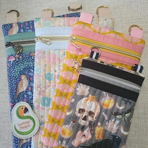 May include: Four zippered pouches with different fabric patterns. The pouches are made of quilted fabric and have a variety of colors and designs. The pouches are lined with a black fabric and have a zipper closure. The pouches are perfect for carrying small items like keys, phones, or makeup. The pouches are also great for organizing your purse or backpack. The pouches are made by Sunthaga Designs.