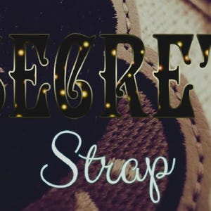 Pode incluir: A imagem apresenta as palavras "SECRET Strap" em uma tipografia decorativa. A palavra "SECRET" está em uma fonte escura e ornamentada com detalhes amarelos, enquanto "Strap" está em branco, em escrita cursiva. O fundo é desfocado e texturizado.