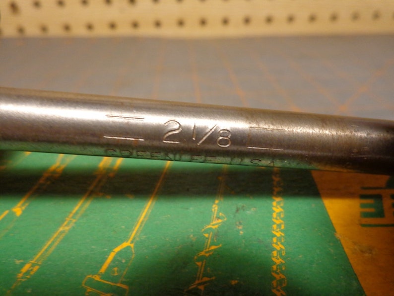 May include: A silver metal wrench with the text "2 1/8" and "COBEKI  U.S.A." engraved on the side.