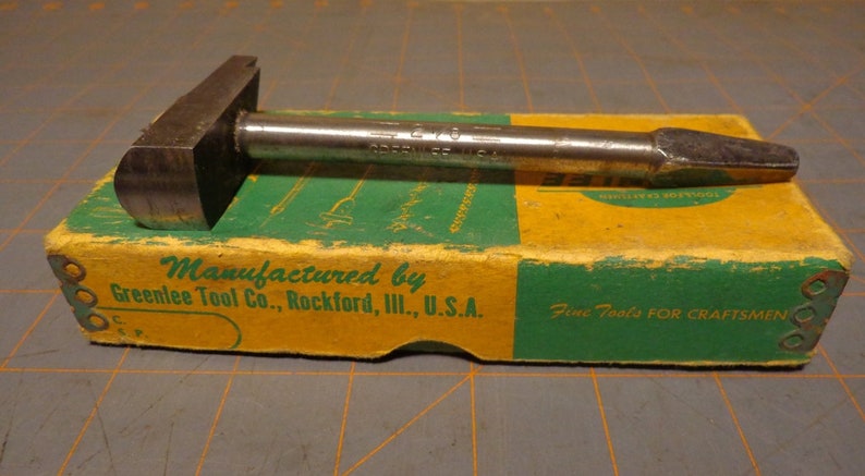 May include: A vintage metal tool with a wooden handle, labeled "Greenlee Tool Co., Rockford, Ill., U.S.A." and "Fine Tools For Craftsmen".