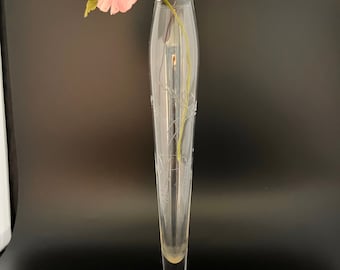 May include: A clear glass bud vase with an etched design and a silver base. A single pink flower is in the vase.