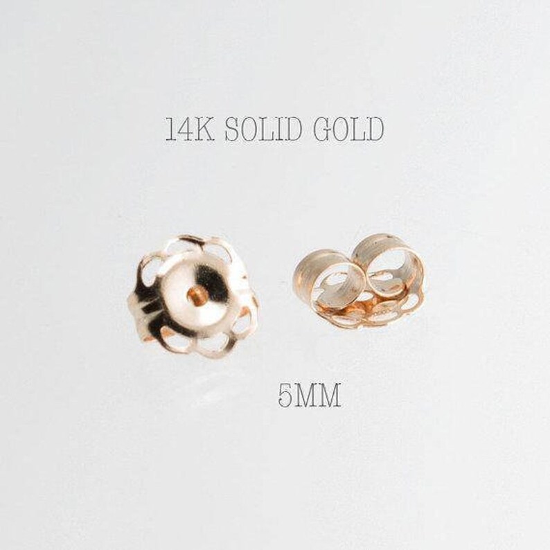 May include: Two 14K solid gold earring backs. One is a flower-shaped design, and the other is a butterfly-shaped design. The text in the image reads "14K SOLID GOLD" and "5MM".