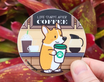 May include: A round sticker with a cartoon corgi dog holding a cup of coffee. The sticker says "Life Starts After Coffee" and has the Tiny Hearts logo.