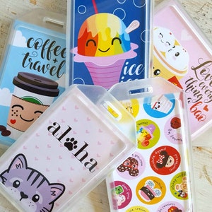May include: A set of six colorful plastic badge holders with different designs. The designs include a coffee cup with the text "coffee + travel", a rainbow shaved ice with the text "ice", a pink background with the text "Aloha" and a paw print, a pink background with a cartoon cat, a pink background with the text "Love every thing bao", and a pink background with a variety of colorful cartoon stickers.