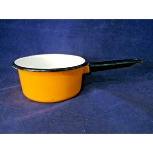 May include: Orange enamel saucepan with a black handle. The saucepan has a white interior and a black rim.