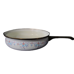 以下が含まれることがあります： 白いエナメル製の鍋に花柄のデザインと茶色の取っ手が付いています