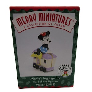 May include: A red box with a white border and green background. The box features a cartoon image of Minnie Mouse in a blue and white polka dot dress, riding a purple and white luggage car. The text on the box reads "Merry Miniatures, A Collection of Charm, Mickey & Co., Minnie's Luggage Car, Third of Five Figurines, Mickey Express."