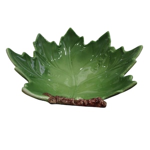 Puede incluir: Un bol de servir de cerámica verde con forma de hoja y un tallo marrón.