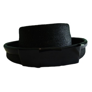 Puede incluir: Un sombrero de paja negro de ala ancha con un lazo de grosgrain negro.
