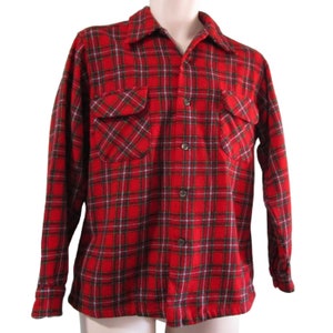 May include: A red and green plaid flannel shirt with a button-up front and two chest pockets.