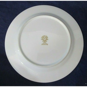 Op de afbeelding: Witte keramische plaat met een gouden rand en een gouden logo in het midden dat "Made in China" en "Royal Crown" met een kroon en het jaar "1974" in het midden van de kroon zegt.