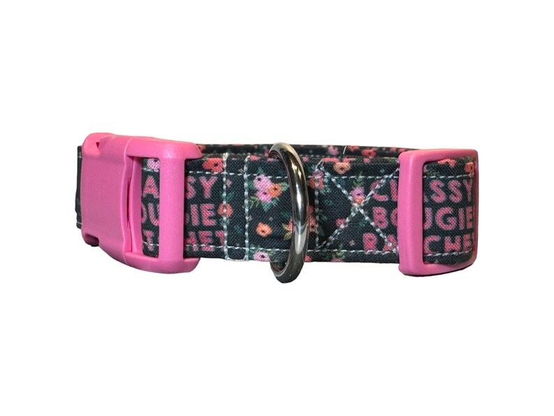 May include: A black and pink dog collar with a floral pattern and the text "Classy Bougie Ratchet" printed on it.