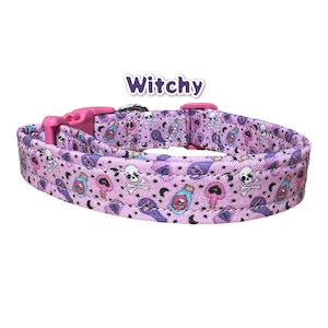 May include: A pink dog collar with a purple and white witchy print featuring potion bottles, skulls, and crescent moons. The collar has a pink buckle and a silver D-ring. The text "Witchy" is printed in purple above the collar.