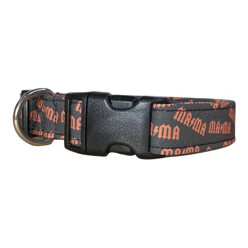 May include: Black dog collar with a silver buckle and orange "Mama" text repeated on the fabric.