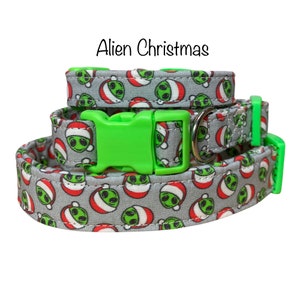 May include: A gray and white dog collar with a green buckle and a repeating pattern of green aliens wearing Santa hats. The collar is labeled "Alien Christmas".