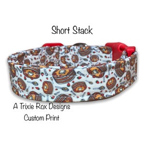 May include: A white dog collar with a red buckle. The collar has a custom print of pancakes and strawberries. The text "Short Stack" is above the collar and "A Trixie Rox Designs Custom Print" is below the collar.
