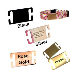 May include: Four different color options for a dog collar slider. The slider is made of metal and has a rectangular shape with two loops on either side. The colors are black, silver, rose gold, and brass. The silver slider has the text "Trixie Rox Designs 3156 Ave of the Cities Moline, IL 563-639-7170" engraved on it.