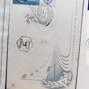 以下が含まれることがあります： 白い封筒に入ったヴィンテージのイスラエルの切手。切手には地球儀、手、ダビデの星が描かれています。封筒にはヘブライ語と英語のテキスト、および1953年9月20日の消印も記載されています。