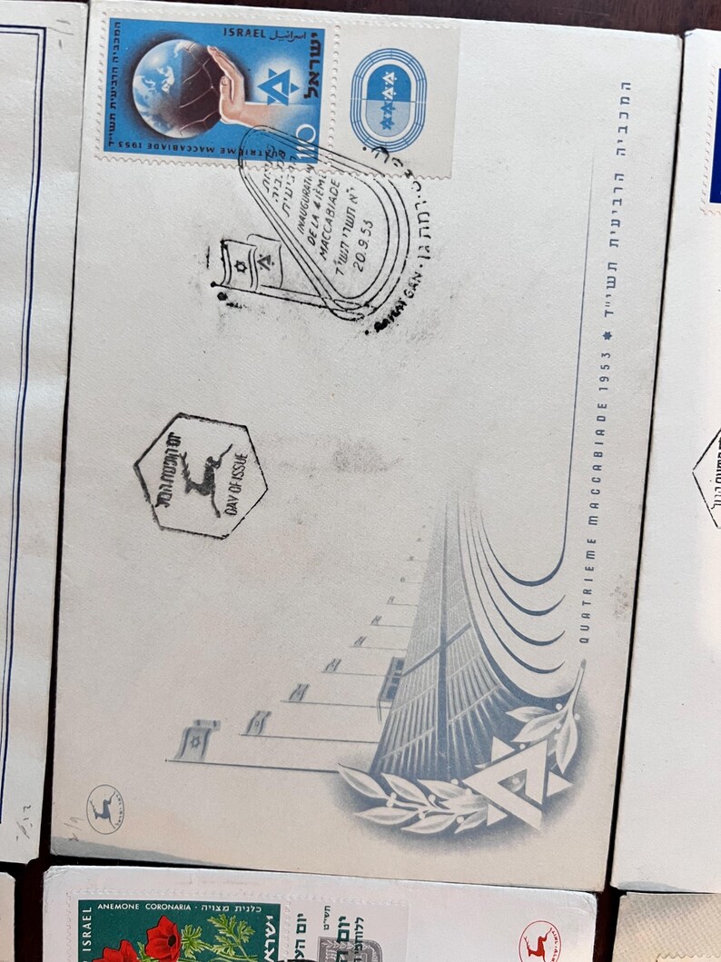 以下が含まれることがあります： 白い封筒に入ったヴィンテージのイスラエルの切手。切手には地球儀、手、ダビデの星が描かれています。封筒にはヘブライ語と英語のテキスト、および1953年9月20日の消印も記載されています。