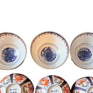 Puede incluir: Colecci&oacute;n de seis cuencos de cer&aacute;mica antiguos. Los cuencos tienen un interior blanco con un dise&ntilde;o azul y blanco en el centro. Los bordes est&aacute;n decorados con un patr&oacute;n floral rojo y azul. La parte inferior de los cuencos tiene un dise&ntilde;o de drag&oacute;n rojo y naranja.